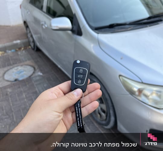 מפתח רכב מול מכונית חונה על מדרכה